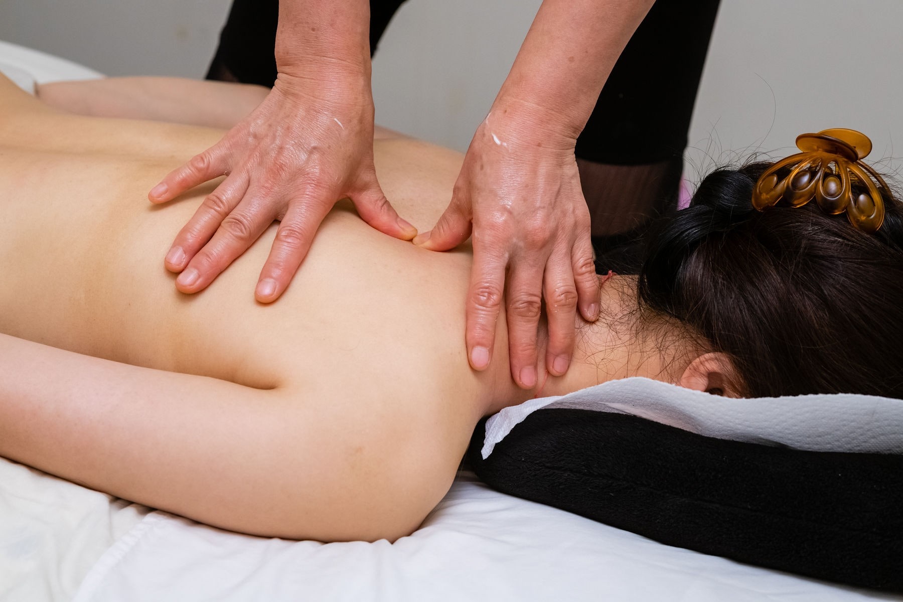 Tuina therapist massaging deep a woman's open back